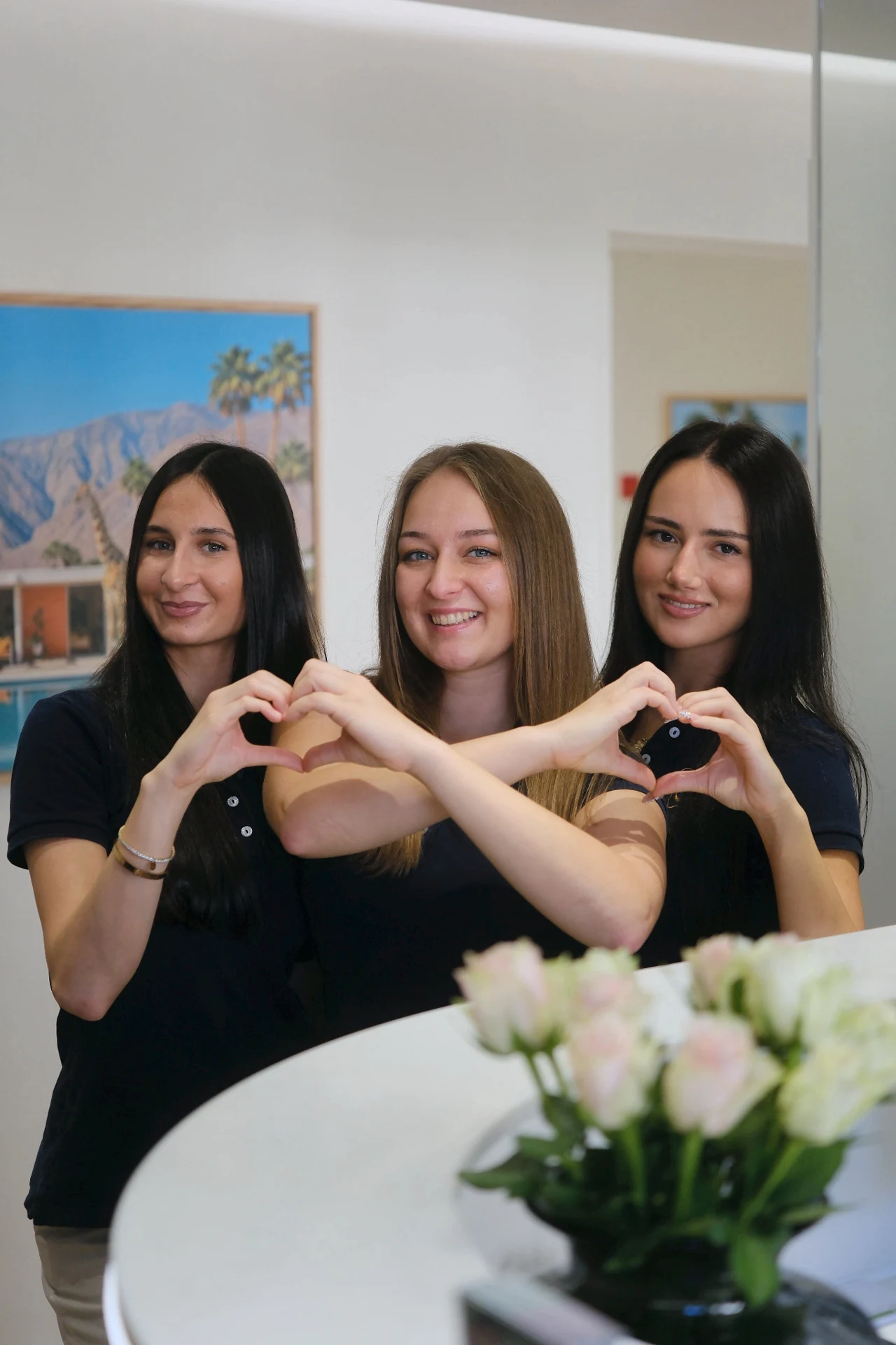Three team members forming a heart together